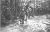 Photograph of troops advancing through swamp