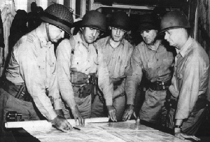 Photograph of Vandegrift and his staff consulting maps