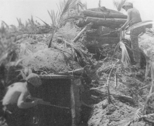 Photograph of wary Marines inspecting a Japanese bunker
