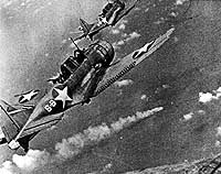 Combat photograph of Dauntlesses over damaged Japanese
        cruiser