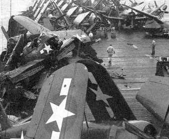 Photograph of Attu with wrecked aircraft on
                  flight deck